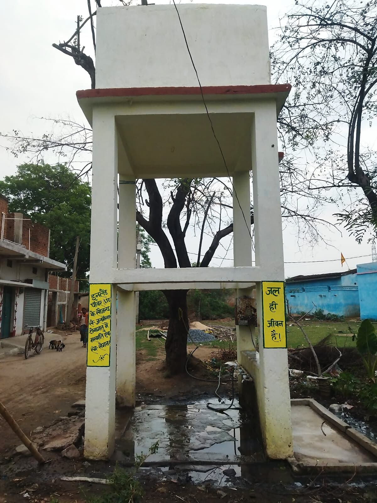 A repaired and repainted village water tower (jalminar) near Inland Nagar, marked with a 'water is life' notice.