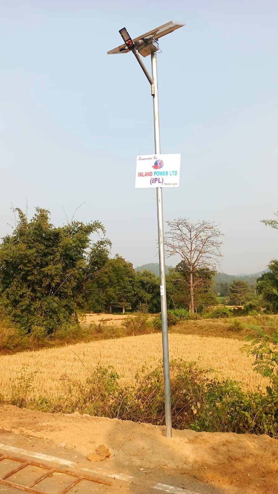 A solar-powered street light installed with Inland Power's support, overlooking farmland near the plant.